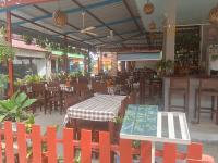 ドン・デトにあるNing Ning Bungalowのテーブルと椅子、テーブルと椅子が備わるレストランを併設しています。