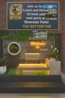 una señal para un hotel con un banco y plantas en Riverside Hotel, en Cobram