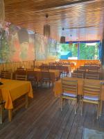 Adrasan Çıtır Pansiyon في Kumluca: غرفة طعام بها طاولات وكراسي وشاشة كبيرة