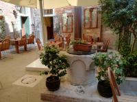 a patio with tables and potted trees and chairs at Locanda La Corte in Venice