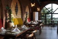 ein Restaurant mit Holztischen und -stühlen und Fenstern in der Unterkunft Club Paradiso Hotel in Alanya