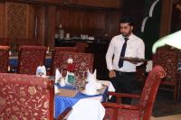 ein Mann hält einen Teller in einem Esszimmer in der Unterkunft Sea Shell Hotel - Sales & Booking Office in Bāiljuri