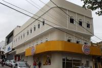 Un edificio en una calle con coches aparcados delante. en Hotel Reobot Center, en Garanhuns