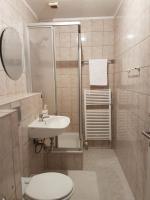 a bathroom with a toilet and a sink and a shower at Hotel Restaurant Rhodos in Elsterwerda