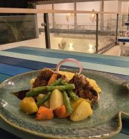 een bord met eten met vlees en groenten op een tafel bij Brizo Paradiso in Matara