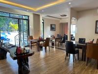 sala de estar con suelo de madera, mesas y sillas en Viet Hoa Hotel & Residence Cat Ba - Rooftop Pool, en Cat Ba