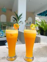 twee glazen sinaasappelsap zittend op een tafel bij Brizo Paradiso in Matara