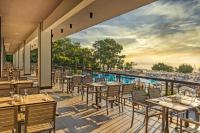 a restaurant with tables and chairs on a deck at Kimeros Park Holiday Village - Ultra All Inc. Kids Concept in Kemer