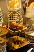 a basket filled with muffins and pastries on a table at Tam Coc Oasis Resort & Spa in Ninh Binh