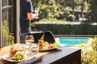 Una mesa con un plato de comida y una copa de vino. en Contact Hôtels Le Savigny & Spa, en Blacé