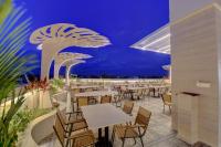 a restaurant with tables and chairs at night at Hotel Warma Palace in Yeola