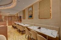 a restaurant with white tables and chairs and a chandelier at Hotel Warma Palace in Yeola