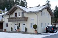 a white house with a car parked in front of it at Appartement Horngacher in Scheffau am Wilden Kaiser