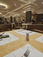 RS Hôtel Karam Resort في ورززات: غرفة طعام بها طاولة عليها شوك ومناديل