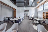a restaurant with white tables and chairs and a mirror at Shenzhen Guanlan Sanyi Yundu Yaduo X Hotel in Shenzhen