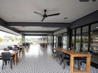 een restaurant met tafels en stoelen en een plafondventilator bij Bankaew Hotel in Ban Kaeo