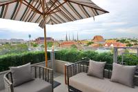 a balcony with two chairs and an umbrella at Riva Arun Bangkok in Bangkok