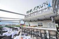 a restaurant with tables and chairs on a balcony at Riva Arun Bangkok in Bangkok