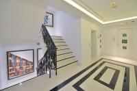 a hallway with stairs and a painting on the wall at Riva Arun Bangkok in Bangkok