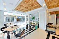 a living room with a couch and tables and chairs at Riva Arun Bangkok in Bangkok