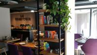 a dining room with a table and a book shelf at Campanile Nancy Centre - Gare in Nancy