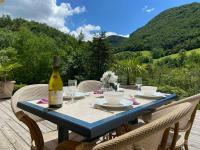 a bottle of wine sitting on a table with chairs at Camping Le Gallo Romain in Barbières