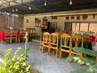 Hotel Restaurant Fitahiana Logde Ampefy - Site 2 Tsarahafatra II في Ampefy: مطعم مع كراسي خشبية وطاولة وطاولة وكراسي