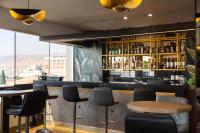 伊洛VIP Hotel的酒吧配有黑色椅子和带瓶子的吧台