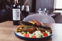 伊洛VIP Hotel的桌上的一小块食物,加上一杯葡萄酒