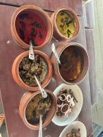 um grupo de tigelas cheias de diferentes tipos de alimentos em Tidal Blend Resort em Turavūr