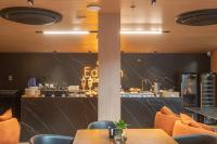 ein Restaurant mit Tischen und Stühlen und einer Theke in der Unterkunft Bless Hospedagem - Flat 117 premium beira mar de cabo branco in João Pessoa