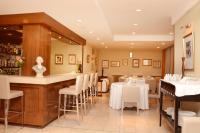 un ristorante con bar e tavoli e sedie bianchi di Hotel Dorá a Mar del Plata