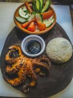 Un plato de comida con un pulpo y un bol de verduras. en Casa A'more, en Cuatunalco