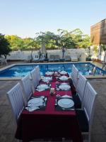 Una mesa larga con platos y cubiertos junto a una piscina. en Flower Of Life Hotel, en Luxor
