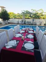 Una mesa de comedor con un mantel rojo y sillas blancas. en Flower Of Life Hotel, en Luxor