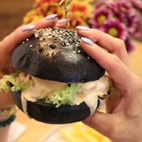 una persona sosteniendo una hamburguesa en sus manos en Freyja Hostal Boutique - Café Bistró, en Bogotá