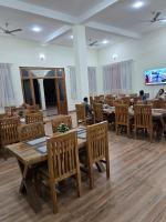 una sala da pranzo con tavoli e sedie in legno di The Van Resort a Bhīmlāt