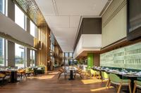 にあるEastern Wenlan Hotelのテーブルと椅子と大きな窓のあるレストラン