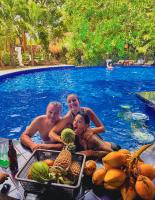 a group of people sitting in a swimming pool with fruit at Sundaras Infinity Jungle Resort & Spa in Dambulla