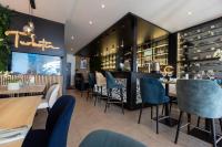 a restaurant with tables and chairs and a bar at Hotel De La Mer in Quiberon