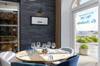 a wooden table in a restaurant with wine glasses at Hotel De La Mer in Quiberon