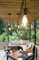 eine Terrasse mit Sofas, Tischen und Lichtern in der Unterkunft The Compass Rose Ubud in Ubud