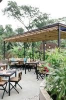 eine Terrasse mit Tischen und Stühlen unter einem Pavillon in der Unterkunft The Compass Rose Ubud in Ubud