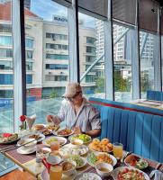 Un uomo seduto a un tavolo con piatti di cibo di INFINITY OCEAN PALACE PANORAMA Nha Trang Center a Nha Trang