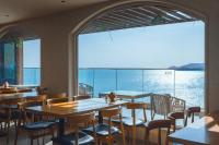 a restaurant with tables and chairs and a large window at Qingdao Momer Cliff Ocean View Villas in Qingdao