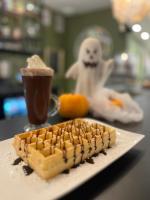 Un plato con un gofre y una bebida en una mesa. en Hôtel Pont Rouge , Carcassonne, en Carcassonne
