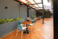 Un patio con mesas y sillas y plantas. en Nouveau Hotel, en Accra
