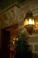 a light hanging from a stone wall with a plant at Hotel Argantonio in Cádiz