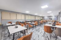 une salle de classe avec des tables et des chaises dans une cafétéria dans l'établissement Jingyue Yaduo Hotel, à Yiwu