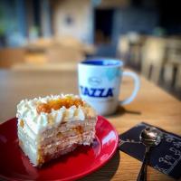 Ruka Trek Suite في كوسامو: قطعة من الكعكة على طبق أحمر مع فنجان من القهوة